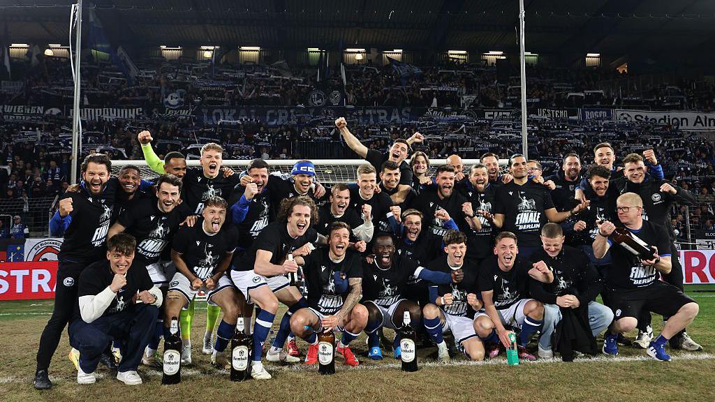 The Arminia Bielefeld squad poses in celebration after reaching the DFB Pokal final