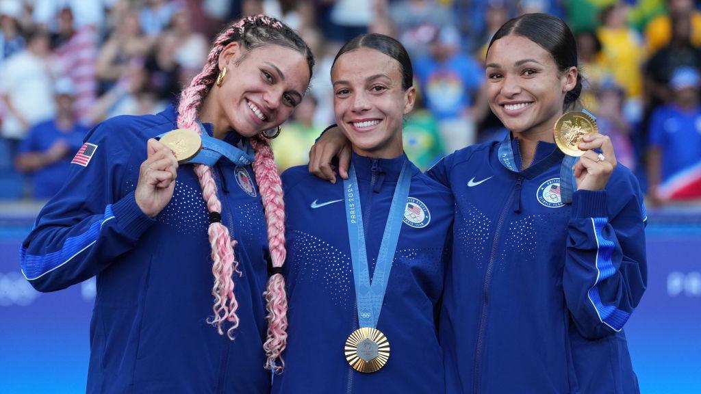 Trinity Rodman, Mallory Swanson, and Sophia Smith hold up their gold medals at Paris 2024