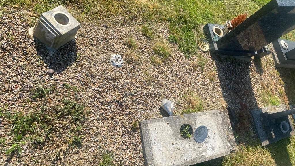 Overturned stone flower holder next to a grave