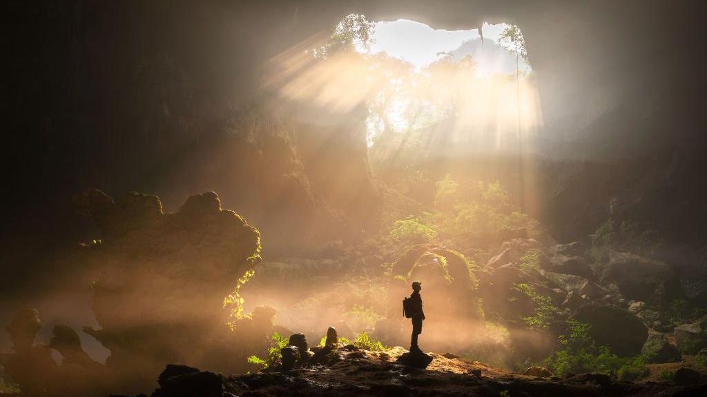 A man standing in the Nongxiang Sinkhole in China