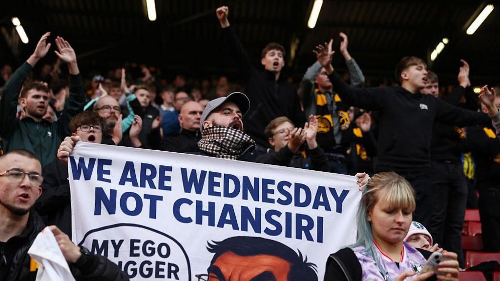 Fans of Sheffield Wednesday hold a banner which reads 'We are Wednesday Not Chansiri'.