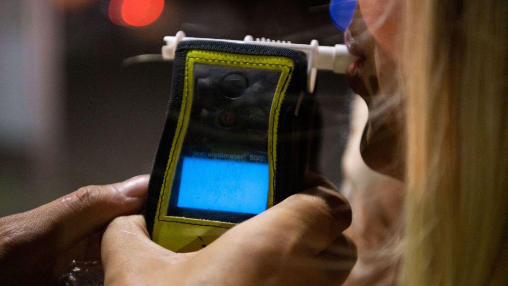 A police officer administers a breathalyser breath alcohol test after stopping a driver