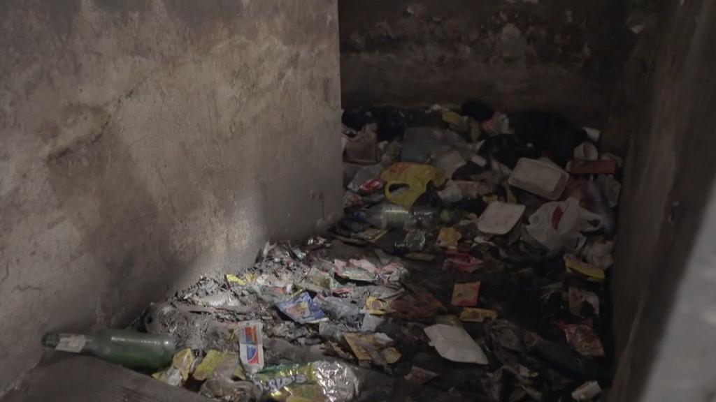 Rubbish and human waste is strewn on some stairs going down.