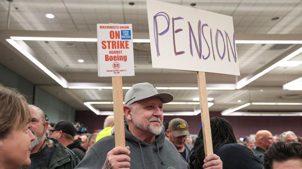 Striking worker holds sign