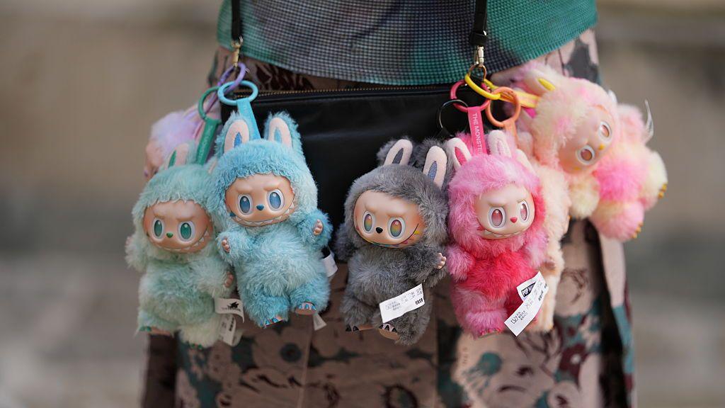 Several Labubu dolls hanging off a bag.
