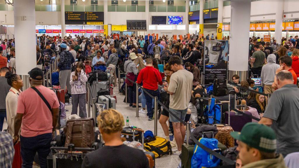 Passengers queue in a busy airport terminal