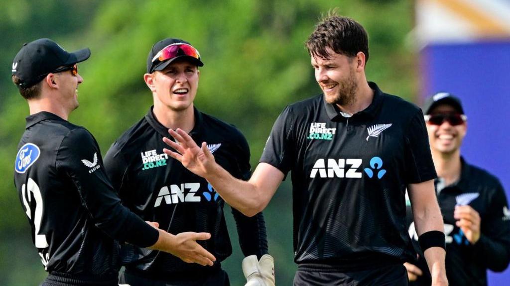 Jacob Duffy celebrates with team-mates after taking a wicket for New Zealand