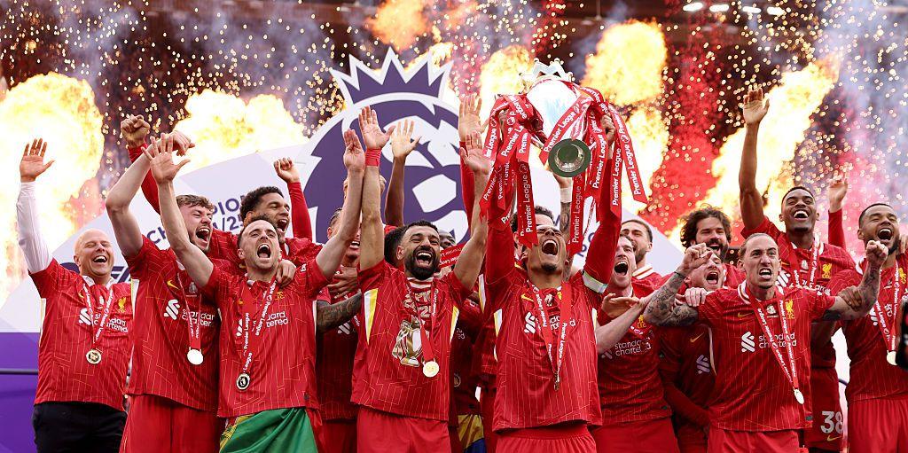 Liverpool captain Virgil van Dijk lifts the Premier League title on the final day of the season at Anfield with his team-mates cheering behind him