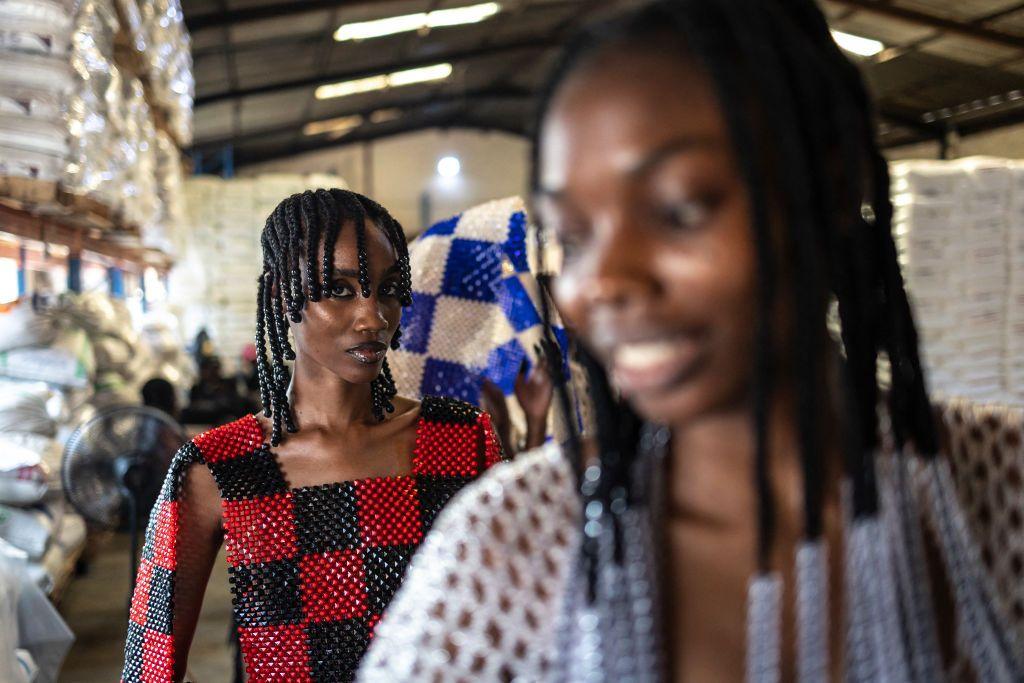 Two models wearing checkerboard beaded clothing by Nigerian designer Bubu Ogisi at Iamisigo brand pose ahead of a private fashion show to launch the Spring- Summer 2025 collection during Lagos Fashion Week, on 27 October.