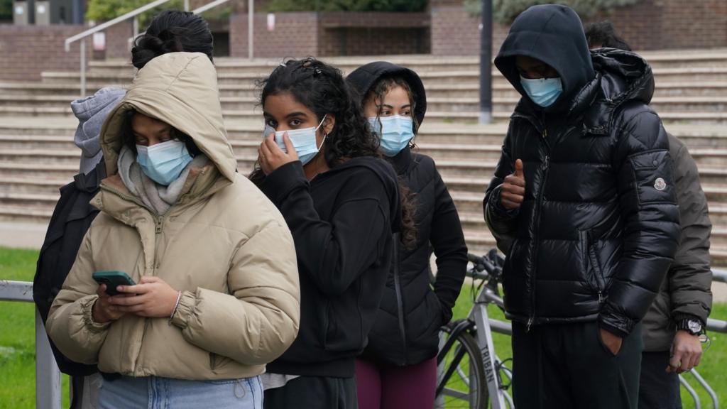 People in masks queuing for antibiotics