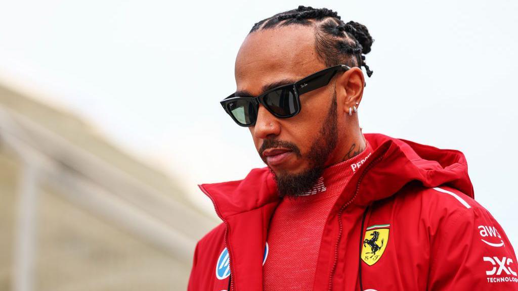 Lewis Hamilton in sunglasses and Ferrari jacket