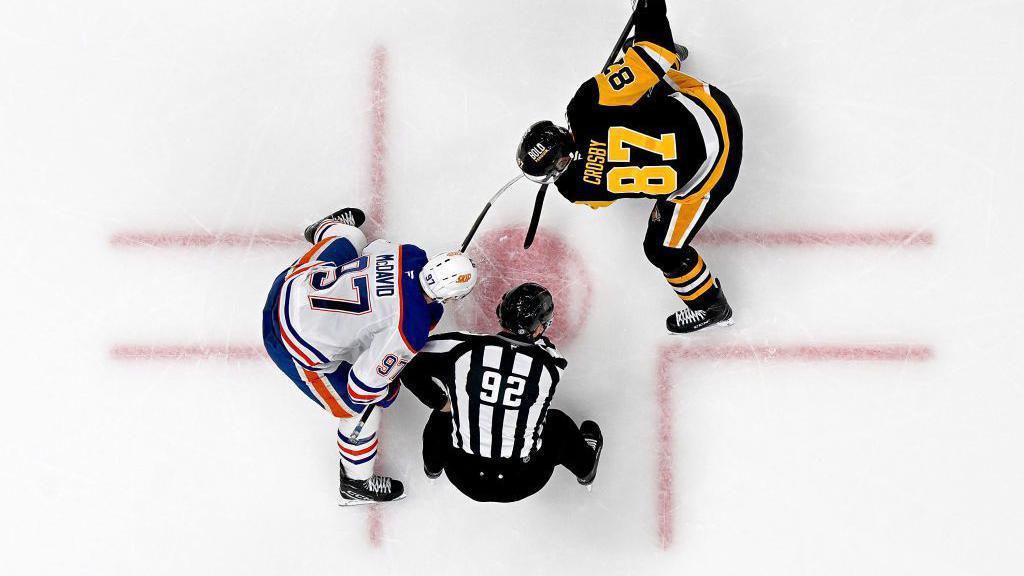 Sidney Crosby of the Pittsburgh Penguins takes a face-off against Connor McDavid of the Edmonton Oilers at PPG PAINTS Arena in Pittsburgh, Pennsylvania