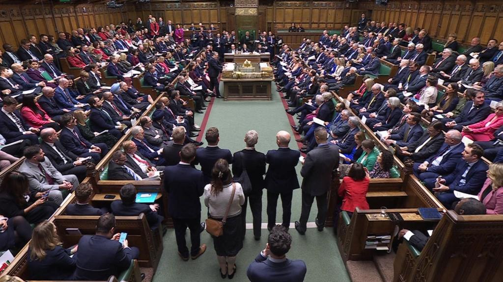 A wide shot of the House of Commons with all benches full of MPs for PMQs