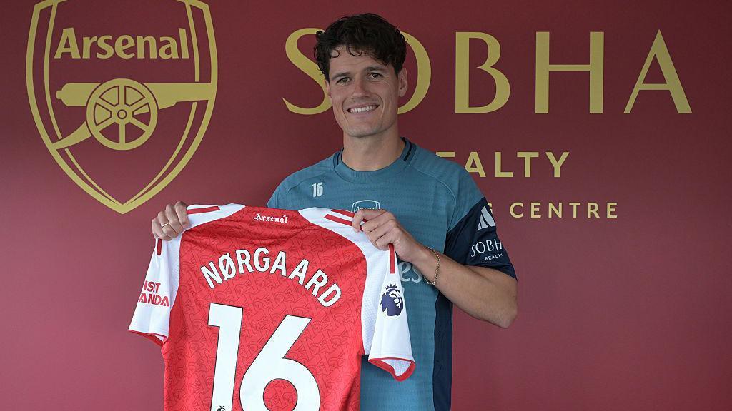 Christian Norgaard holds an Arsenal shirt