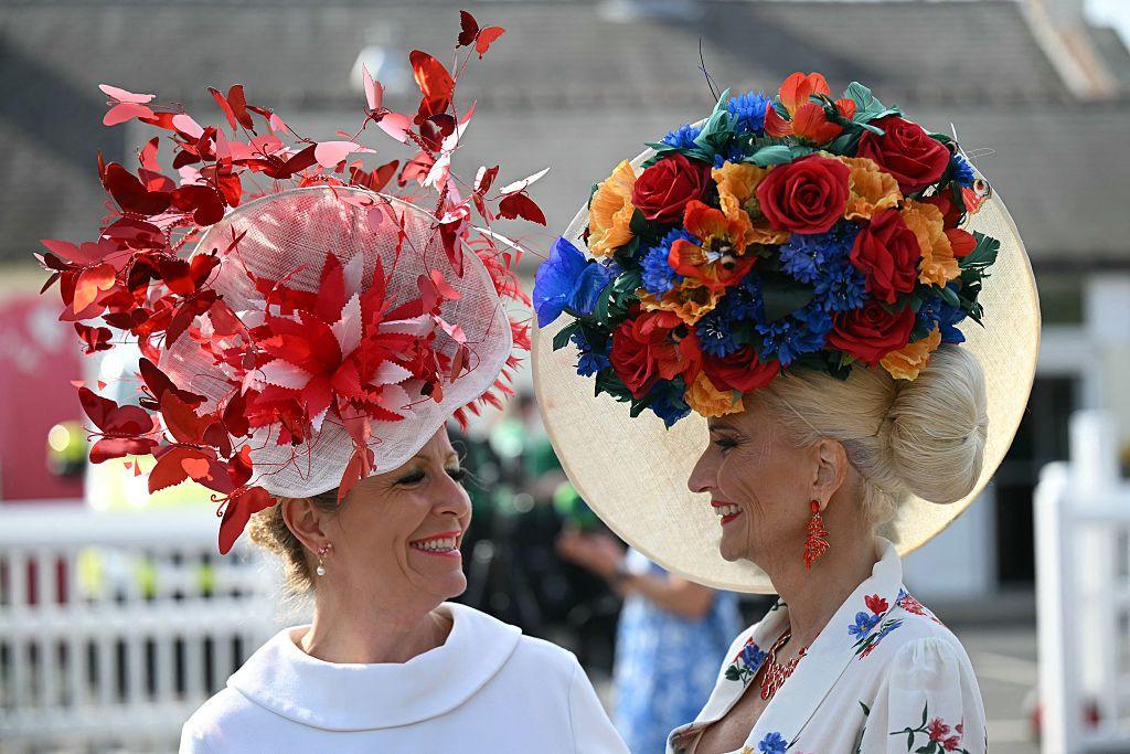 Two women wear fancy hats at the Grand National on Ladies Day