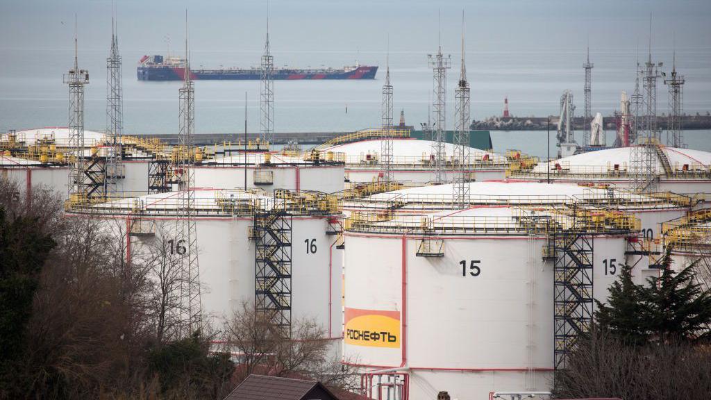 Oil storage tanks as a tanker sails beyond in Tuapse, Russia