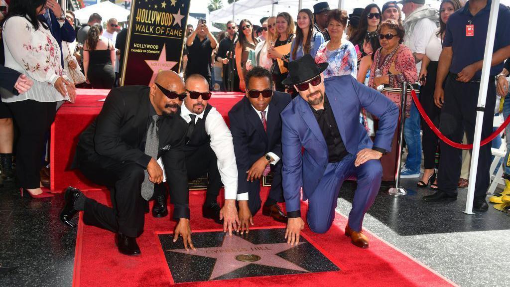 Cypress Hill members Sen Dog (L), DJ Muggs (2-L), Eric Bobo and B-Real (R) pose at their just unveiled Hollywood Walk of Fame Star during a ceremony in Hollywood, California on April 18, 2019