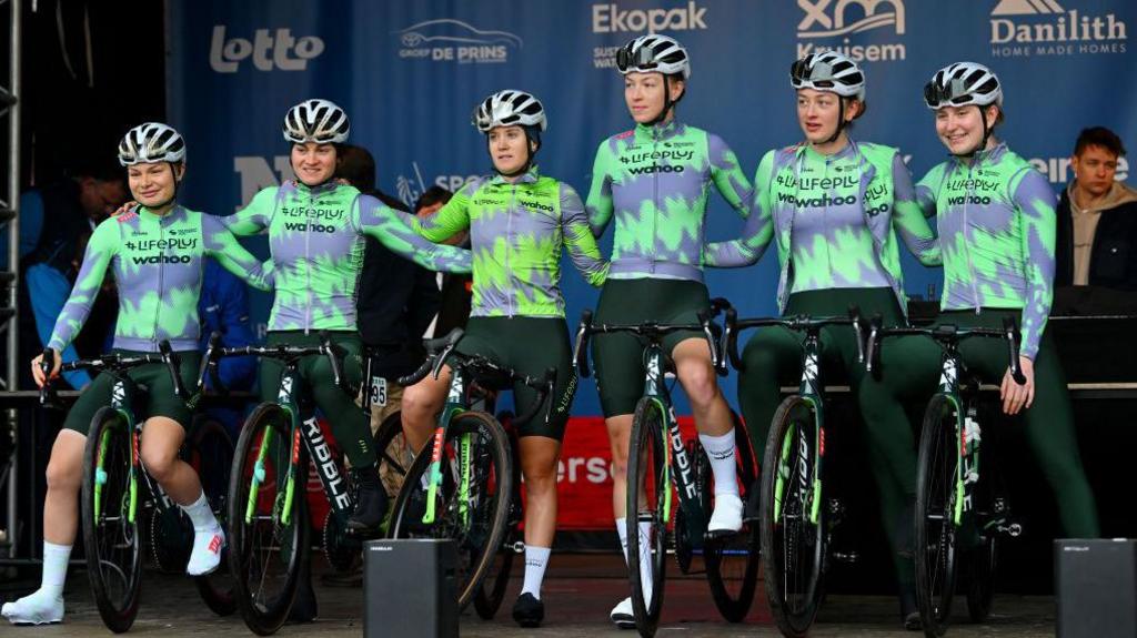 Six cyclists on stage with their bikes