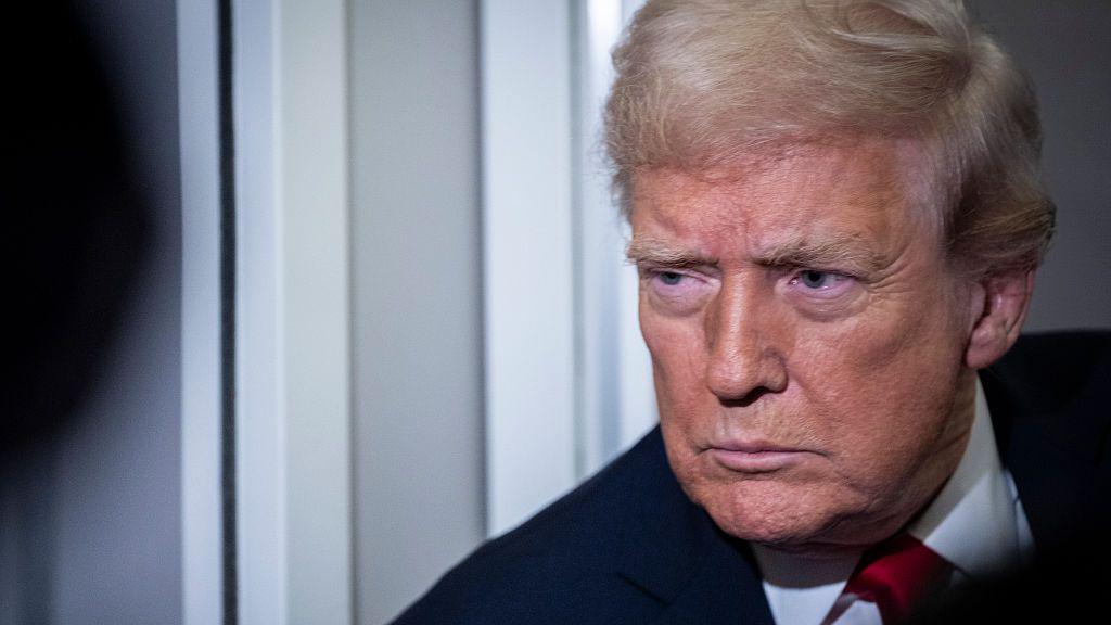 A close photo of Trump, who is wearing a dark suit and red tie