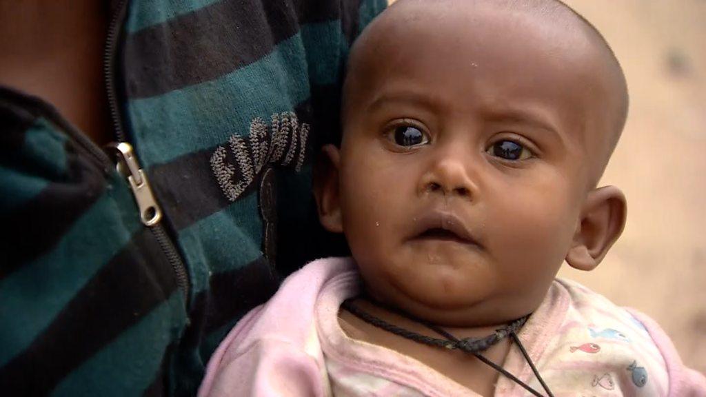 A baby waiting in line for food