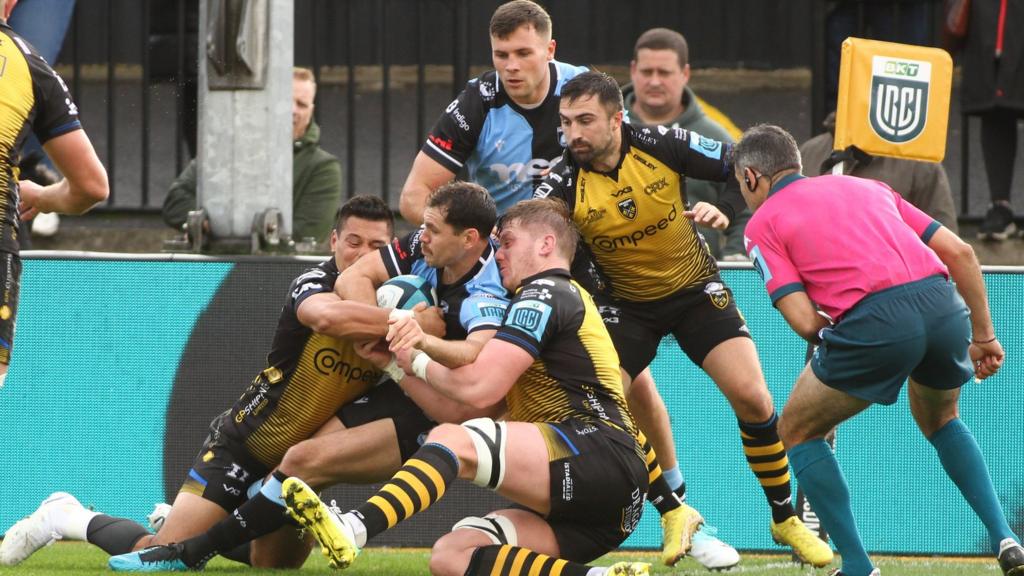 Mason Grady and Rhodri Williams look to get involved as Tomos Williams of Cardiff is held up over the line