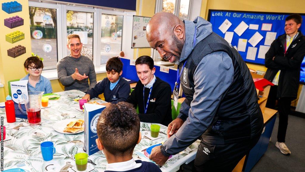 Darren Moore attending a breakfast club in Huddersfield