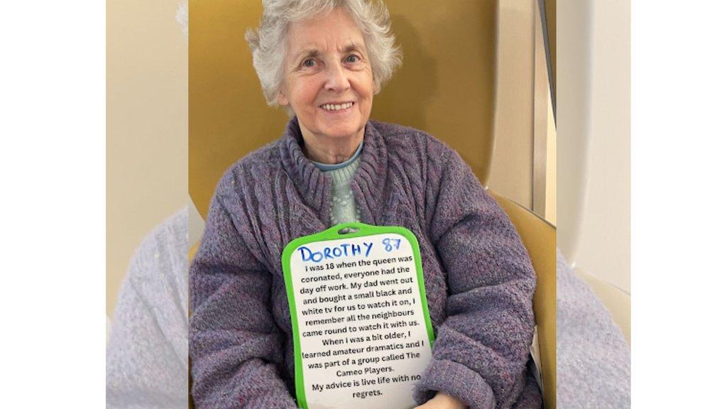 Dorothy sat down holding up her sign.