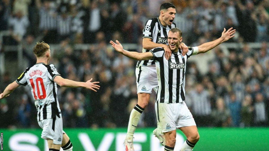 Dan Burn (centre-right) celebrates with Fabian Schar and Anthony Gordon