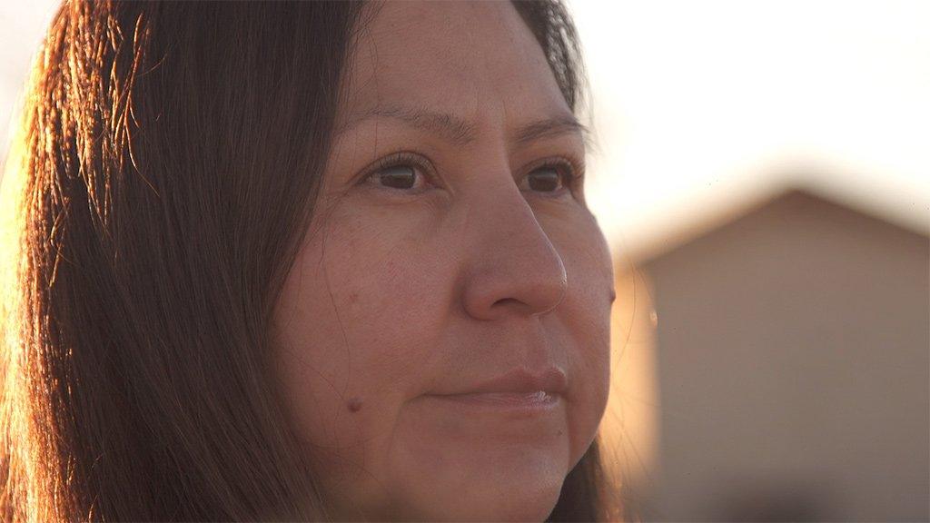 Bea Redfeather looks into the distance at the top of a hill near her home in Shiprock, New Mexico