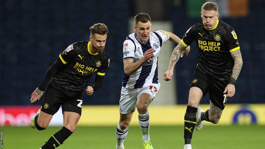 Wigan and West Brom tussle for the ball