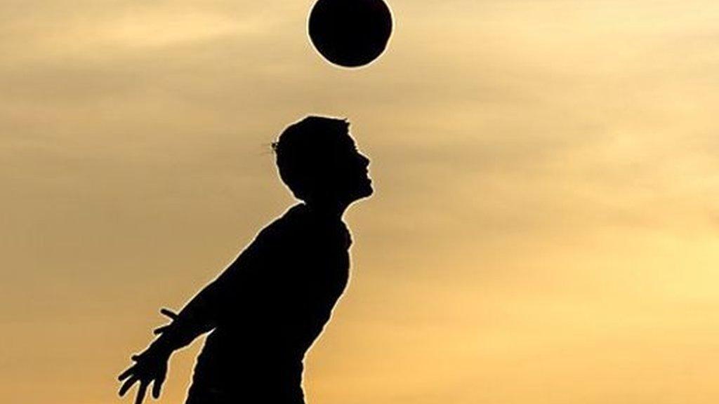 A boy heading a football