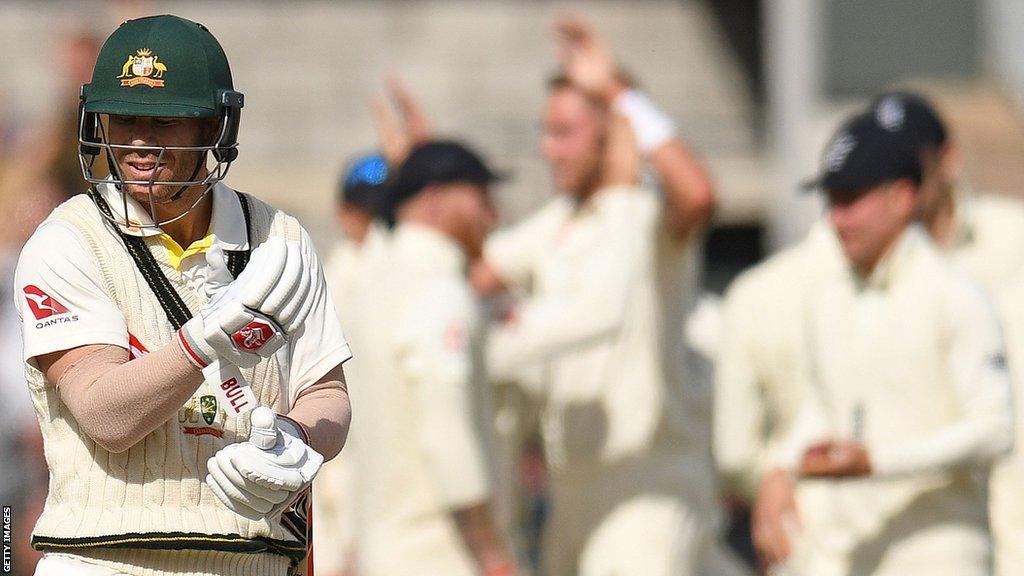 David Warner looking frustrated after being dismissed with England players celebrating in the background