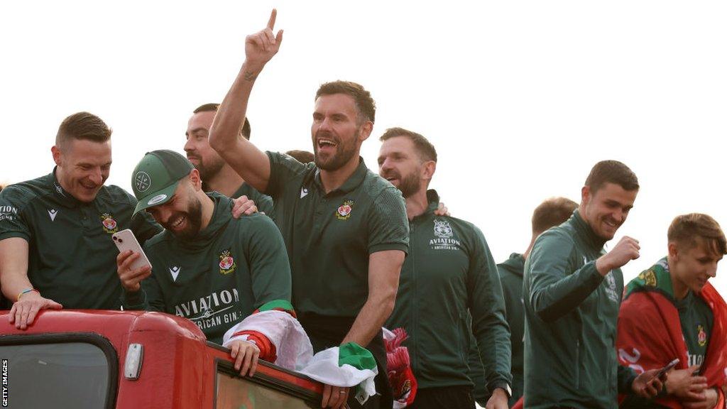 Wrexham players on an open top bus celebrating their promotion