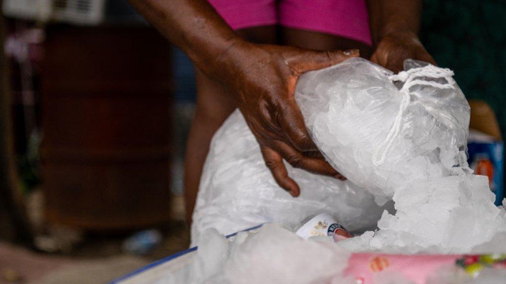 A woman fills an ice chest in Houston, Texas during a 2022 heatwave