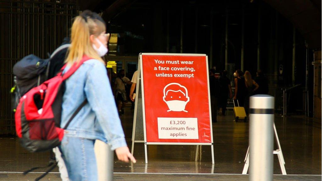 woman walks past sign