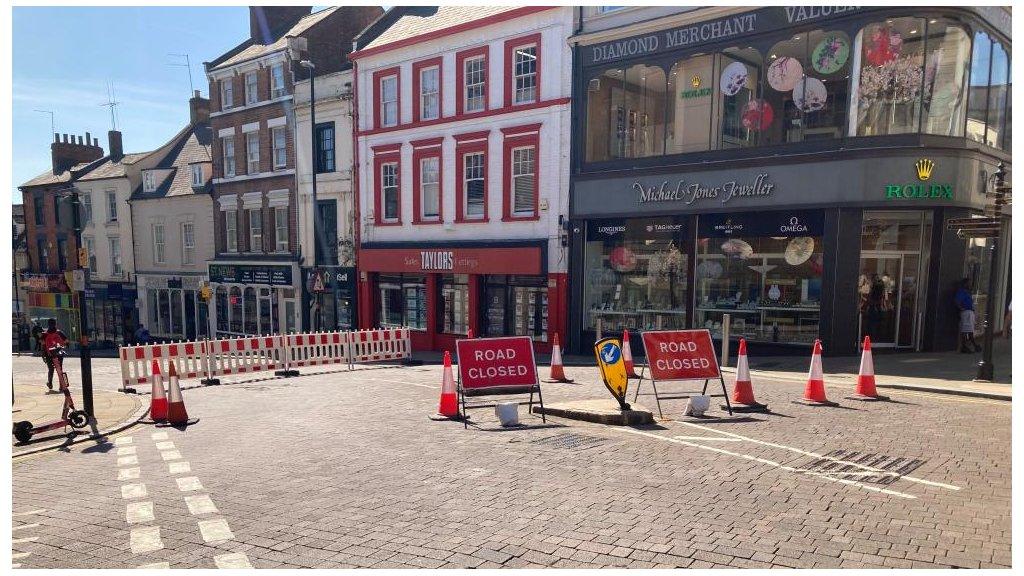 Road closure signs blocking a town centre street.