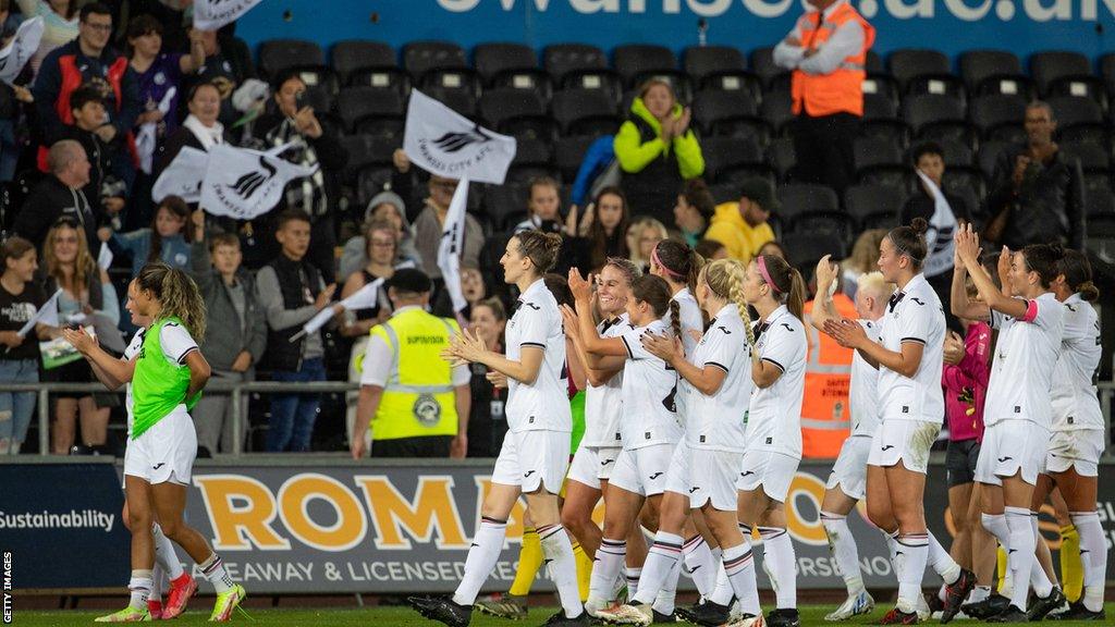 Swansea City players applaud fans