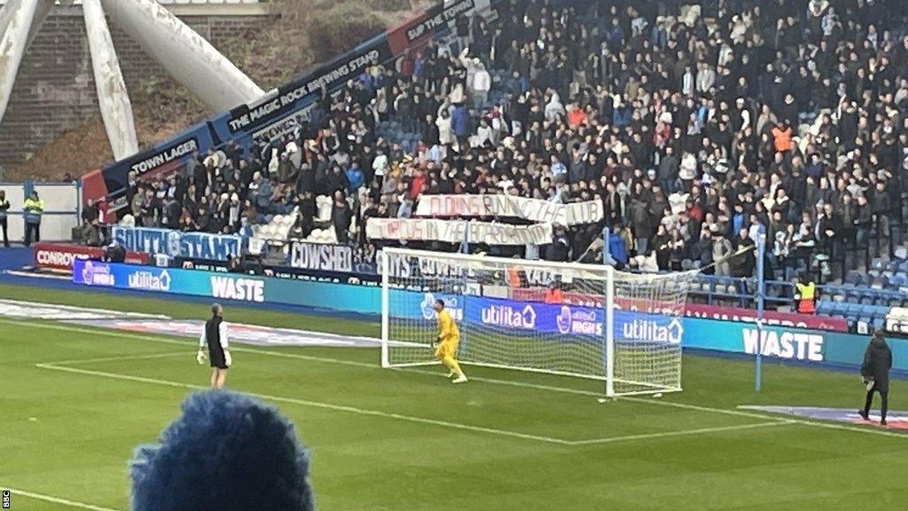 Huddersfield Town fans with banner protesting the running of the club