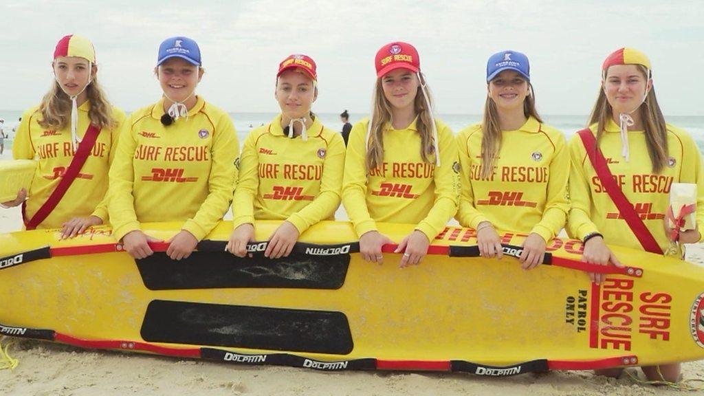 A group of lifeguards with a surf board