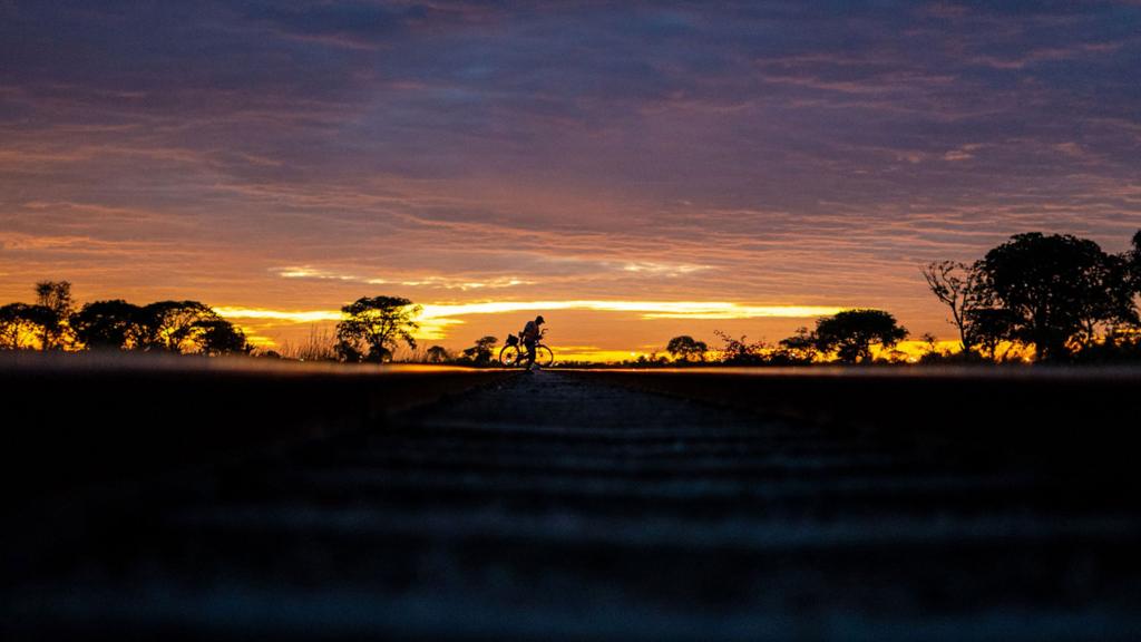 A man on a bicycle at the sun rise or set in Bulawayo, Zimbabwe