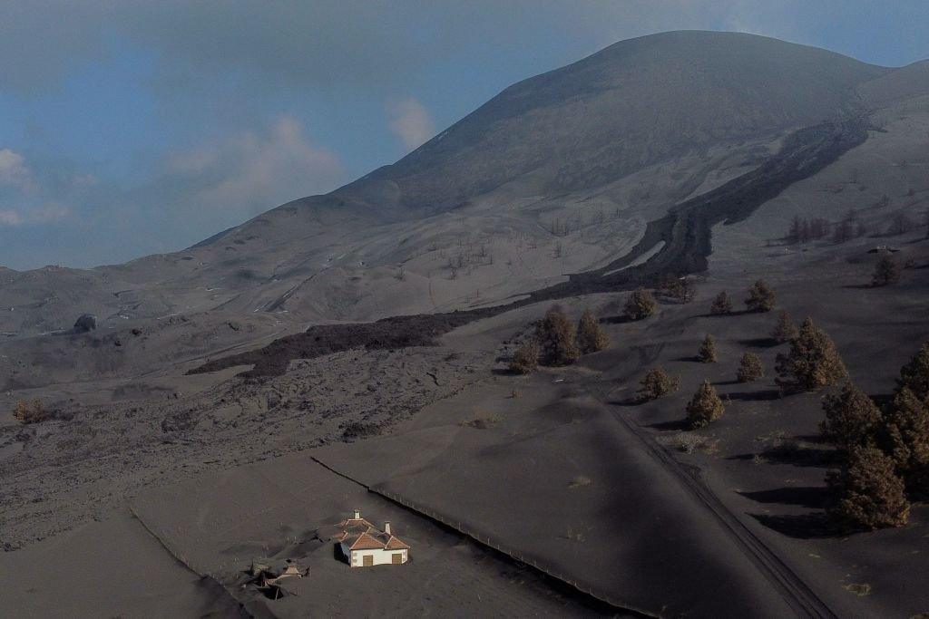 This aerial picture shows a house covered with lava and ashes following the eruption of the Cumbre Vieja volcano