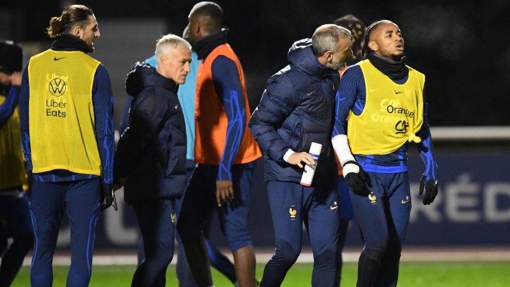 Christopher Nkunku is assisted by staff at France training session