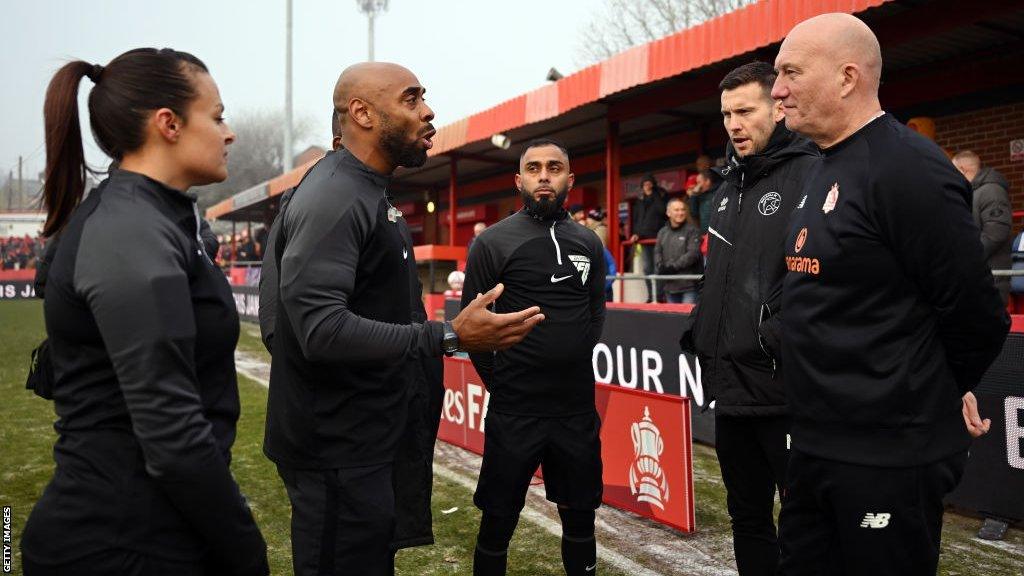 Referee Sam Allison explains his decision to Walsall boss Mat Sadler and Alfreton manager Billy Heath