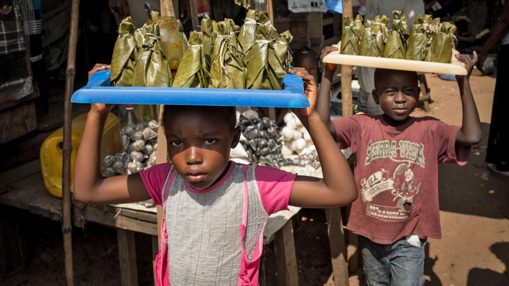 Children sell fish cooked in leaves at a market in Dongo, north-western Democratic Republic of Congo - 2015