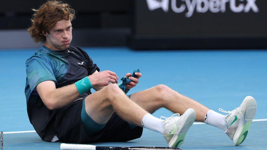 Andrey Rublev sits on the floor after his win