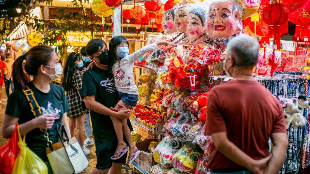 People wearing facemasks as a precaution against the spread of covid-19 browse for Chinese New Year decorations in Chinatown during the eve of the Lunar New Year.