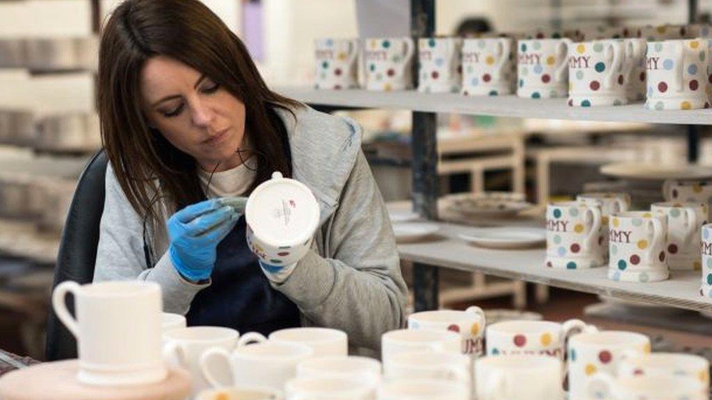 Woman painting mugs