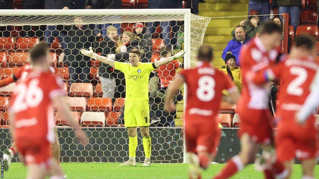 Wycombe goalkeeper Max Stryjek appealing to the referee while the Barnsley players celebrate