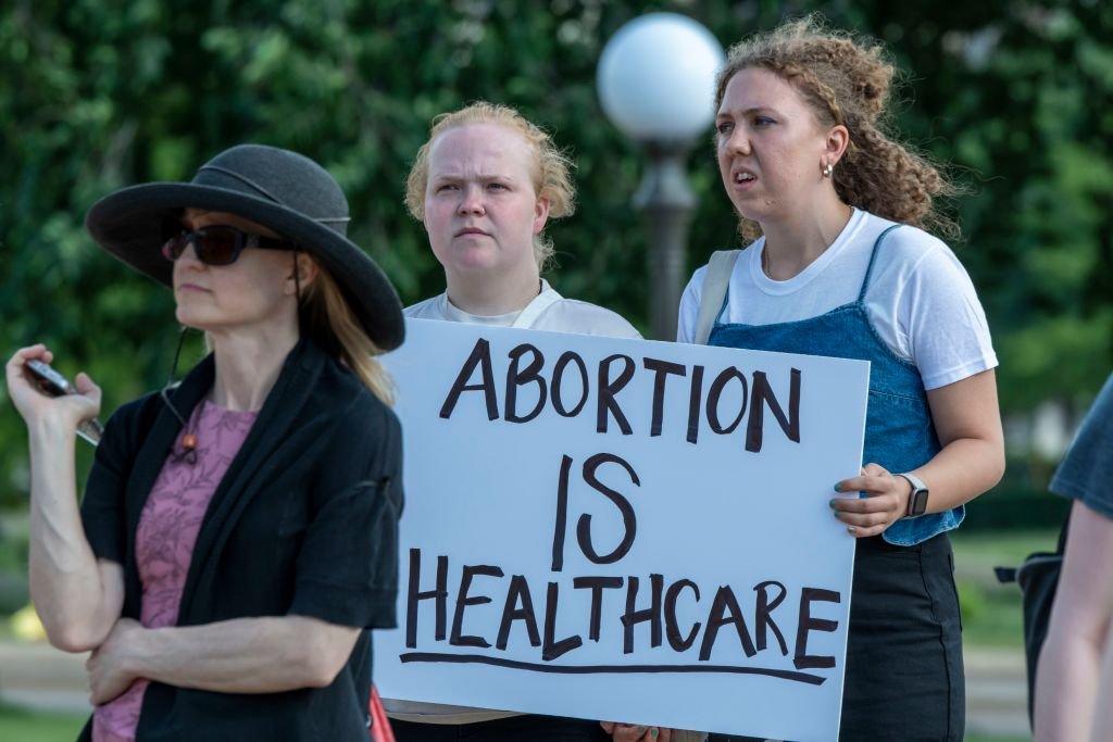 Pro-choice activists hold a sign saying "abortion is healthcare"