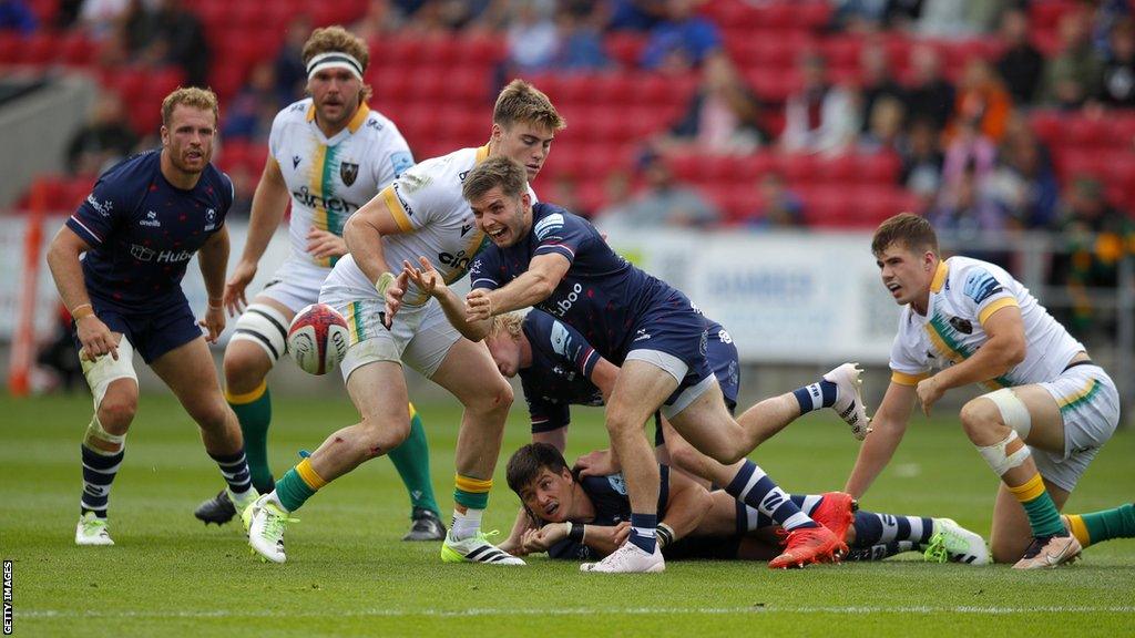 Harry Randall (centre) throws the ball out of a ruck during Bristol's game with Northampton